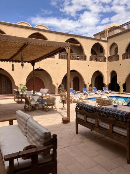 Patio interior con piscina, tumbonas y arcos árabes del Sultana Palace con zona de descanso