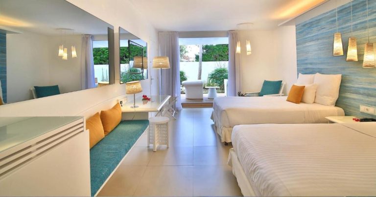 Habitación doble deluxe con dos camas y decoración tropical en La Creole Beach Hotel & Spa