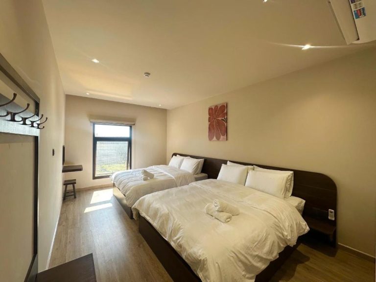 Habitación doble con dos camas matrimoniales y suelo de madera en Le VyN Mang Den