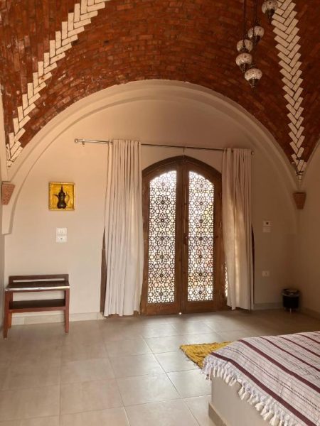 Habitación con bóveda de ladrillo y puerta árabe con celosías en Sultana Palace