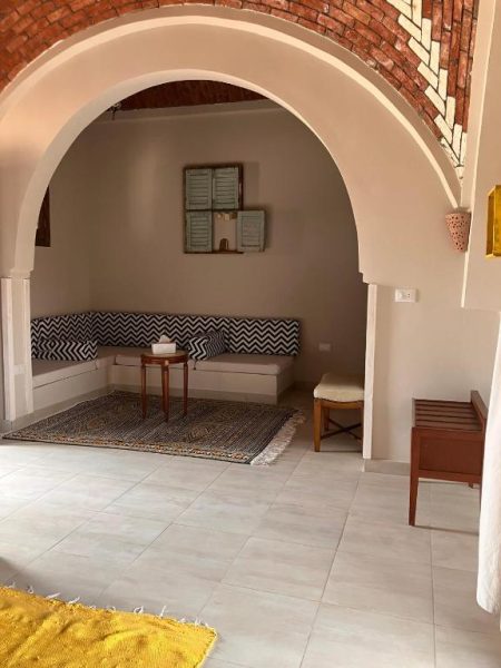 Salón con arco decorativo y sofás de estilo árabe en el Sultana Palace