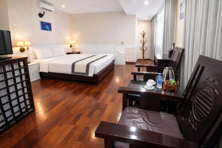 Habitación doble del Orient Hotel con suelo de madera, cama matrimonial y mobiliario clásico oriental