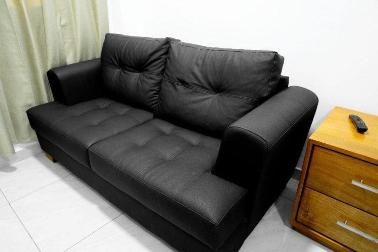 Sofá de cuero negro y mesita de madera en el salón del Hotel Bimini