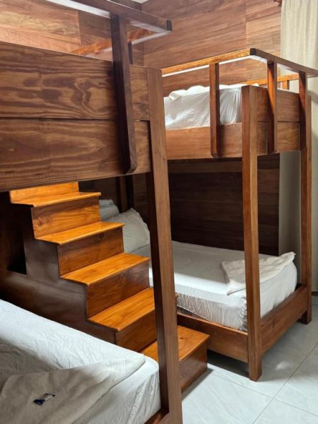 Habitación con literas de madera y escalera integrada en Hotel Bimini, ideal para familias