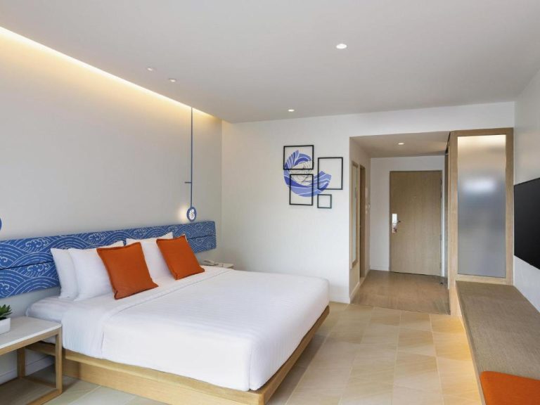 Habitación doble superior con cama king y cabecero azul en Novotel Rayong Rim Pae Resort