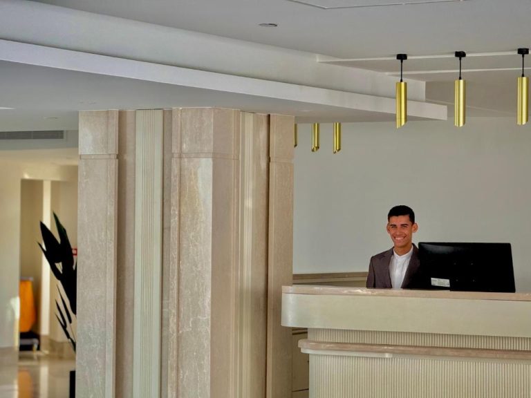 Recepción moderna del Rosetta Hotel & SPA con mostrador de mármol y lámparas doradas decorativas