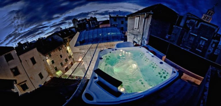 Jacuzzi en terraza exterior nocturna del Jupiter Heritage Hotel con vistas panorámicas a la ciudad