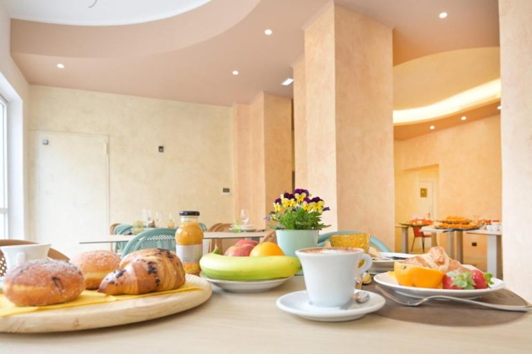 Buffet de desayuno con bollería, frutas y café en el comedor del Hotel Corallo New