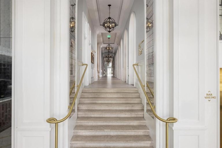 Elegante escalera de mármol con barandillas doradas en el pasillo del Hilton Imperial Dubrovnik