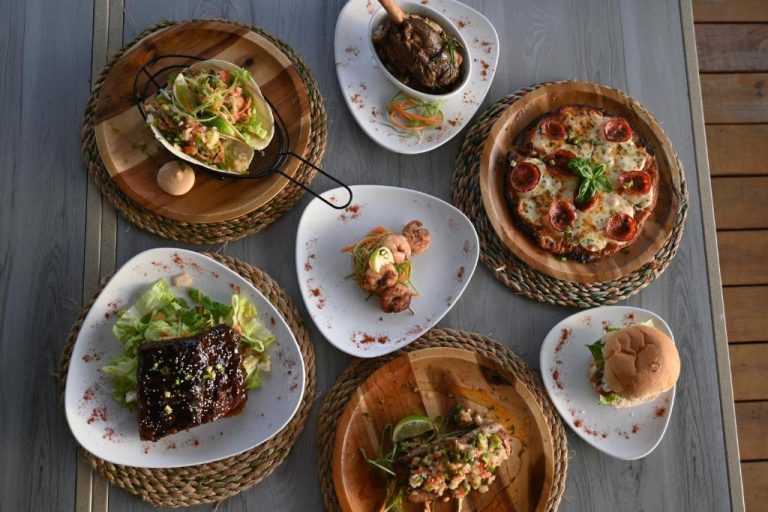 Selección de platos gourmet del restaurante Eden On the Sea con pizza, tacos, carnes y mariscos