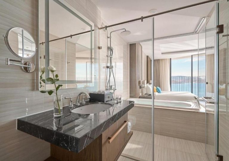 Baño de lujo con encimera de mármol y ducha en Panorama Blue Beach Nha Trang con vistas al mar