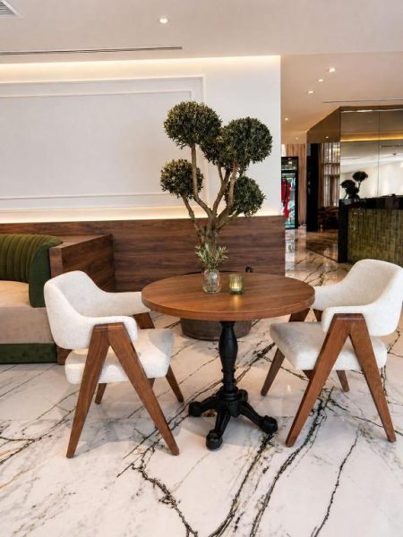 Elegante lobby con mesa de madera y sillones blancos sobre suelo de mármol en L'Adresse Boutique Hotel Tanger