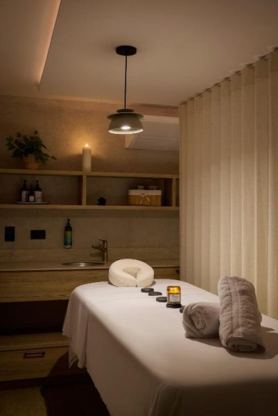 Sala de masajes con camilla y piedras calientes en el spa del Landmark Hotel