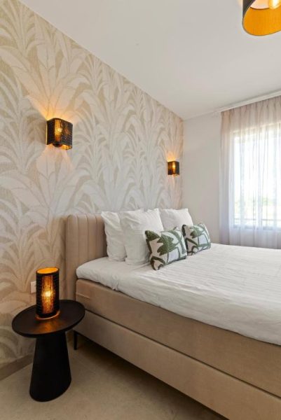 Habitación doble con cama tapizada y decoración tropical en The Ivy Blue Bay Curaçao Golf & Beach Resort