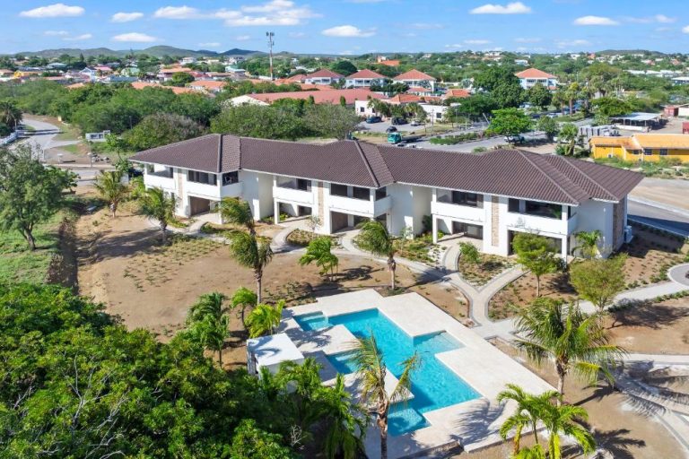 Vista aérea de la piscina exterior y apartamentos de The Ivy en Blue Bay Curaçao Golf & Beach Resort