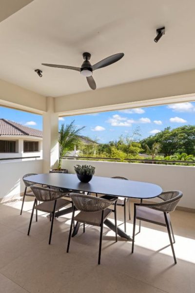 Terraza exterior con mesa de comedor y ventilador de techo en The Ivy Blue Bay Curaçao Golf & Beach Resort