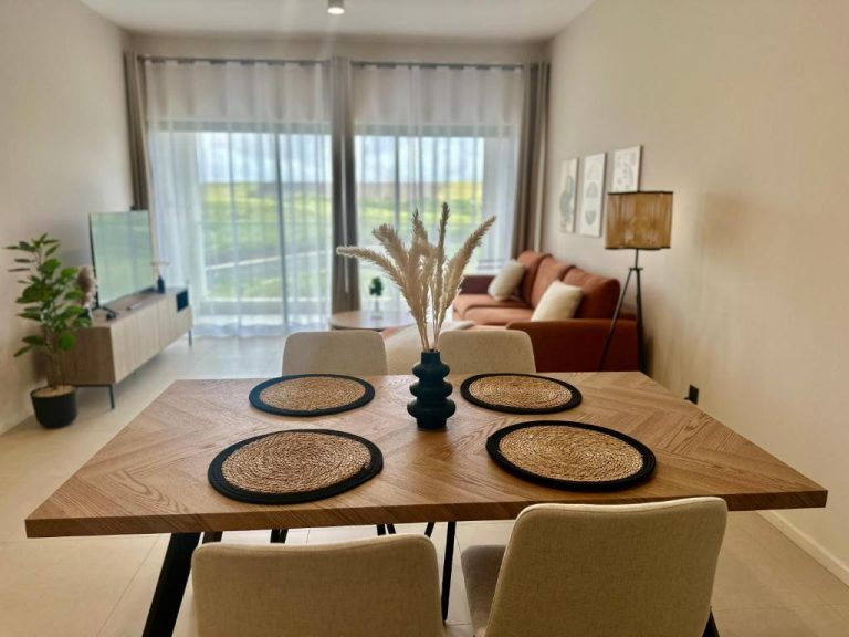 Salón comedor moderno con mesa de madera y sofá en apartamento de Minissy Suites
