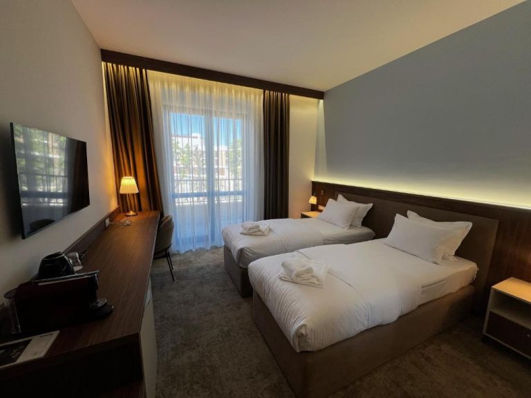 Habitación twin con dos camas individuales, TV y ventanal en Hotel Onogošt
