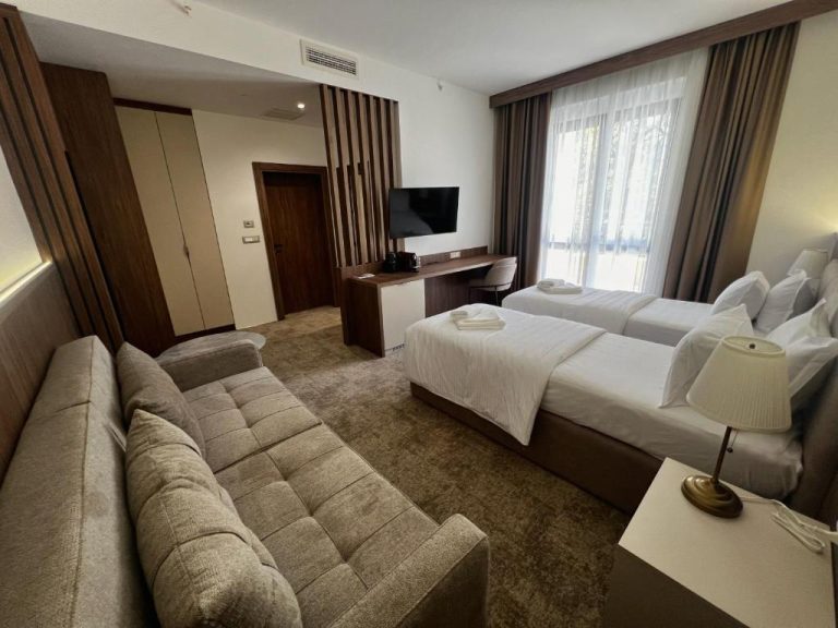 Suite amplia con sofá, dos camas y escritorio con TV en el Hotel Onogošt