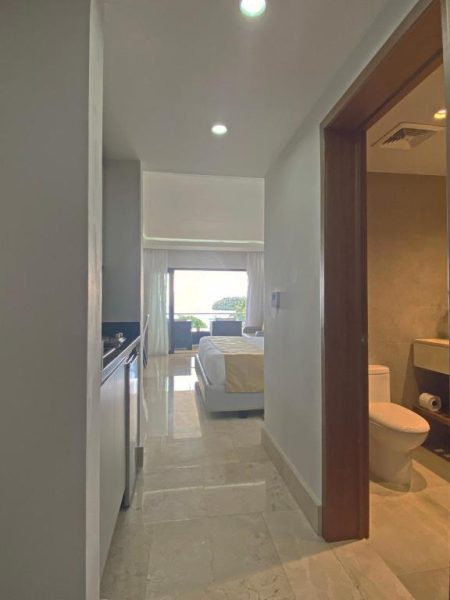 Pasillo con baño y habitación con vista al mar en Hacienda Samana Bay Hotel