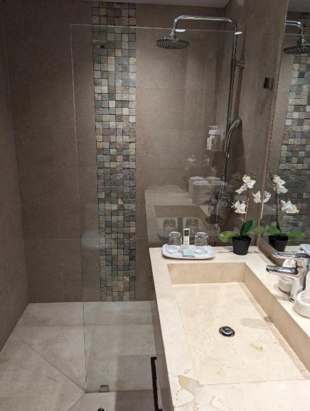 Baño de lujo con ducha de lluvia y lavabo de mármol en Hacienda Samana Bay Hotel
