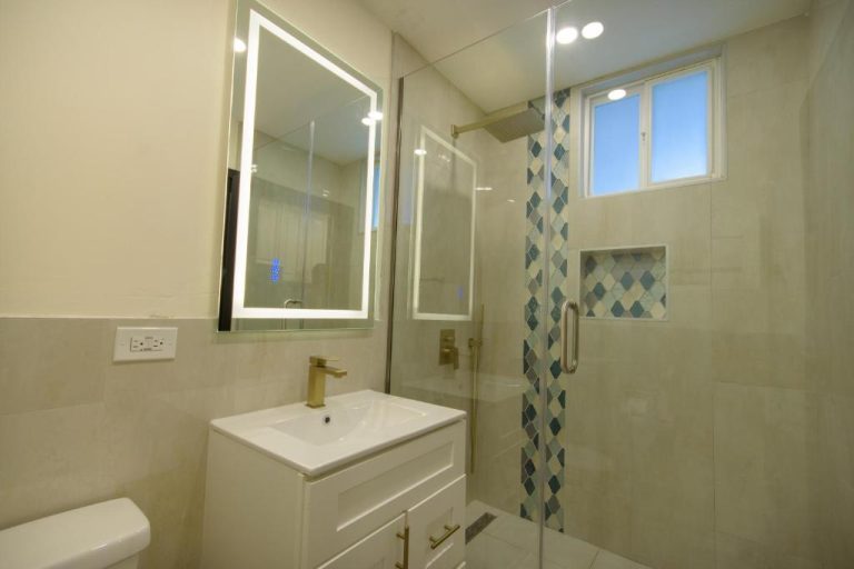 Baño moderno con ducha de cristal y griferías doradas en apartamento Beautiful 1 Bedroom 14 Sandcastles