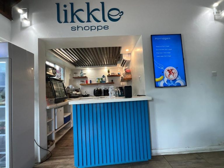 Cafetería Likkle Shoppe con mostrador azul y menú de porridges en el apartamento Sandcastles