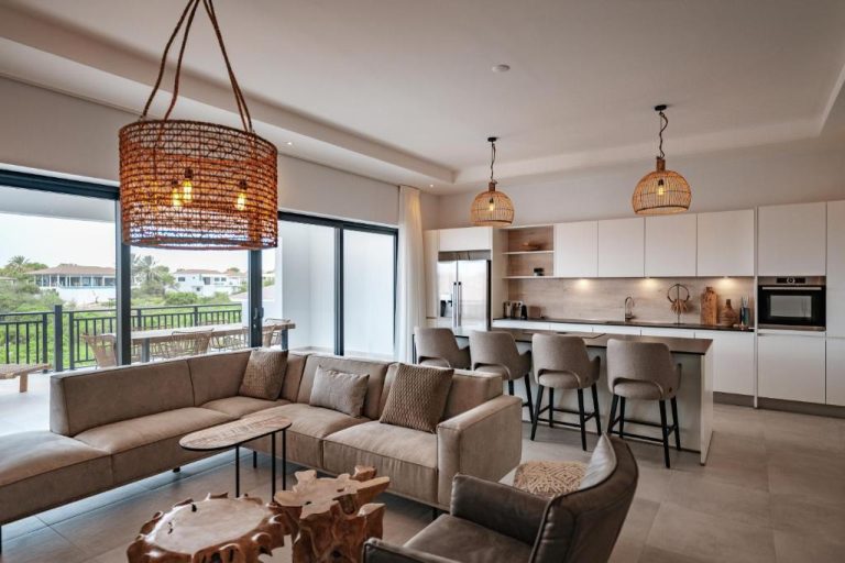 Amplio salón con cocina abierta y decoración moderna en The Breeze Blue Bay Curaçao Golf & Beach Resort