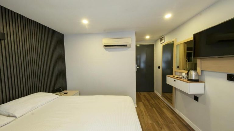 Habitación doble moderna con cama matrimonial, TV y aire acondicionado en Legend Tulip Hotel