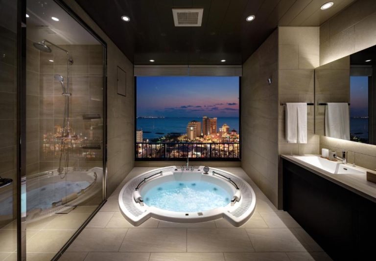 Jacuzzi circular de lujo con vistas nocturnas a la ciudad en RIHGA Royal Resort Okinawa Chatan