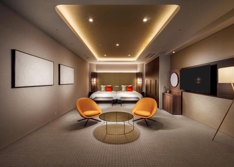 Suite twin de lujo con sillones naranjas y techo iluminado en RIHGA Royal Resort Okinawa Chatan