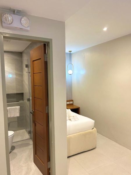 Habitación con cama individual y baño privado con ducha en Olive's Suites