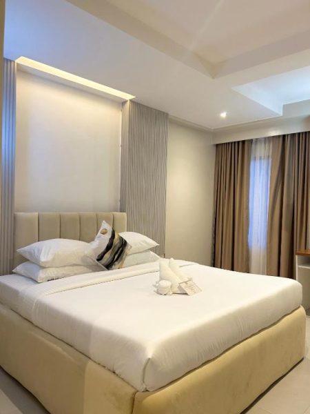 Habitación de lujo con cama doble king size y decoración elegante en Olive's Suites