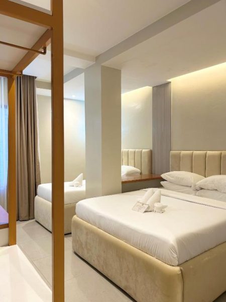Habitación doble de lujo con cama king size y cabecero tapizado en Olive's Suites