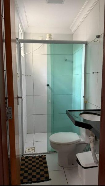 Baño privado con ducha de cristal, inodoro y lavabo del Hotel Sol Brasil