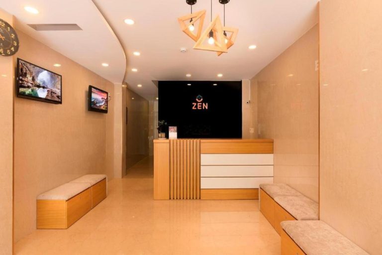 Recepción moderna con mostrador de madera del Zen Hotel Nha Trang con zona de espera