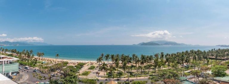 Vista panorámica de la playa y el mar turquesa desde el Zen Hotel Nha Trang con palmeras
