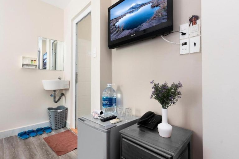 Habitación con TV de pared, minibar y zona de baño en Zen Hotel Nha Trang