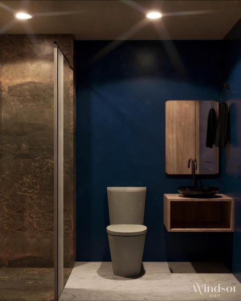 Baño moderno con ducha de vidrio y lavabo negro en el Hotel Windsor Cali