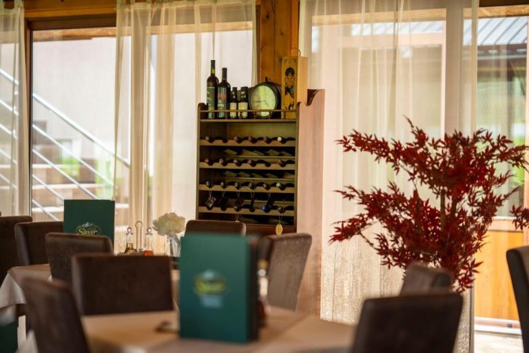 Restaurante del Hotel Sjever con bodega de vinos, mesas elegantes y decoración con planta roja