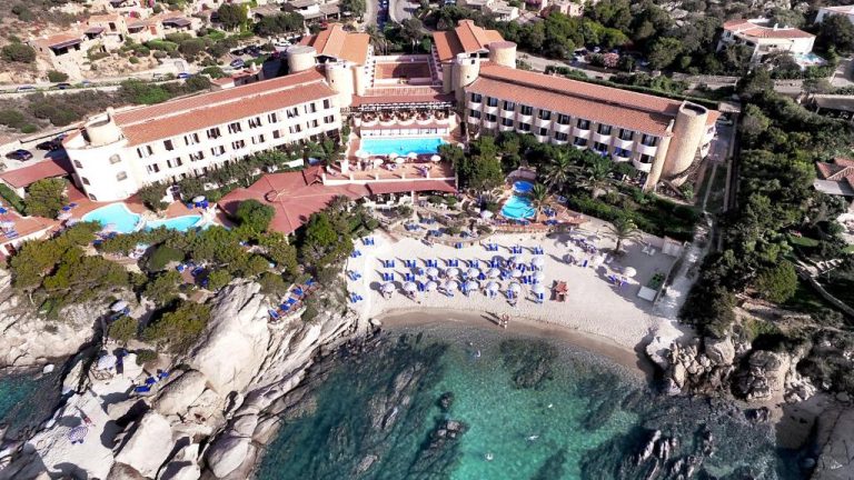Vista aérea del Grand Hotel Smeraldo Beach con piscinas, playa privada y aguas cristalinas en Cerdeña