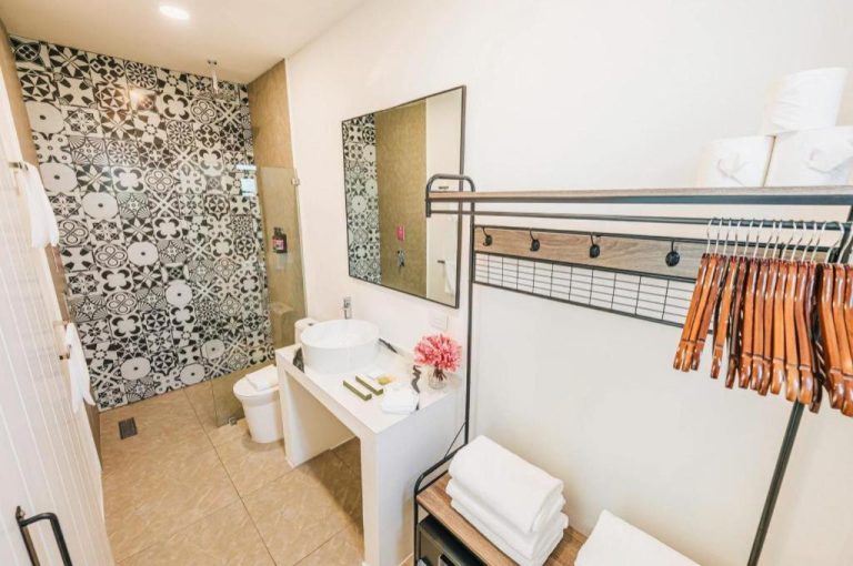 Baño moderno con ducha y azulejos decorativos en blanco y negro del Privada Stays Boutique Hotel