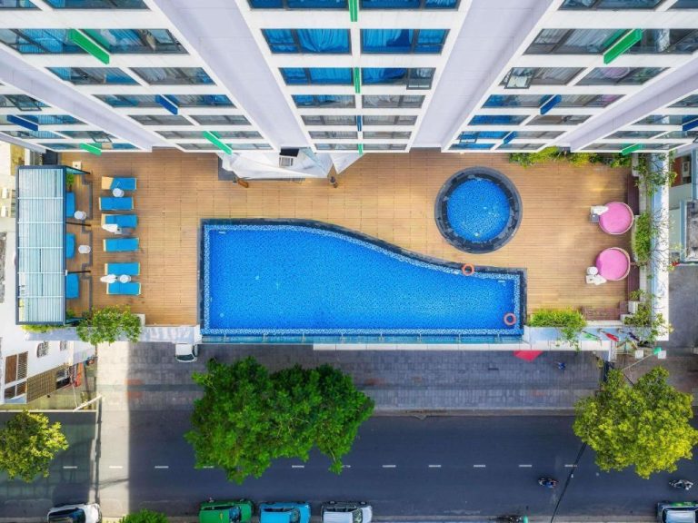 Vista aérea de la piscina exterior en rooftop del ibis Styles Nha Trang con jacuzzi y tumbonas