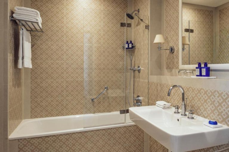 Baño clásico con bañera y ducha de lluvia en The Phoenicia Malta, amenities Acqua di Parma