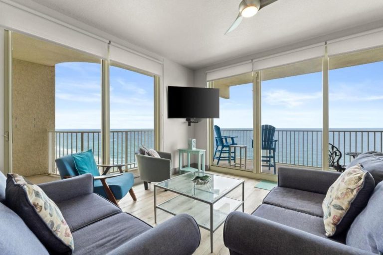 Salón con sofás grises y balcón con vistas panorámicas al mar en Shores of Panama, piso 20