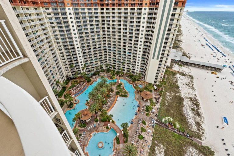 Vista aérea de la piscina exterior con palmeras del Shores of Panama frente a la playa de arena blanca