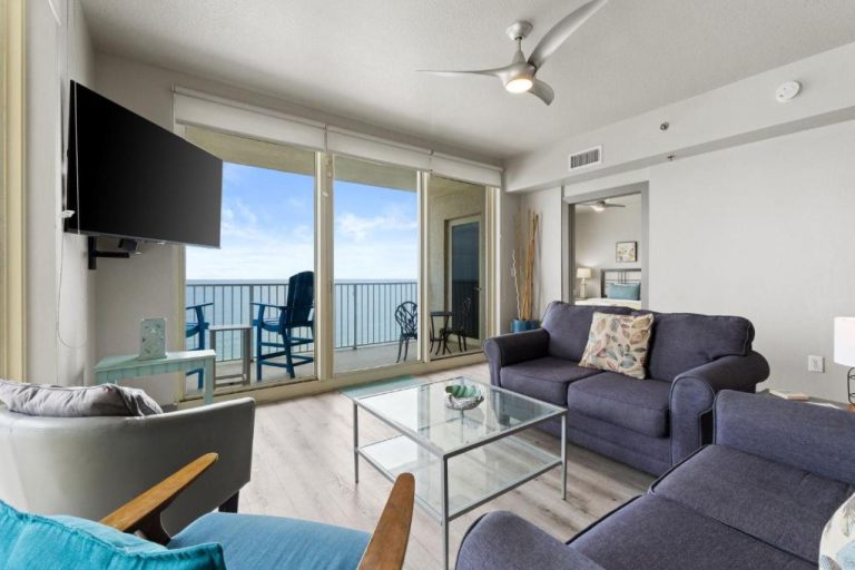 Salón luminoso con sofás azules y balcón con vistas al mar en Shores of Panama, planta 20