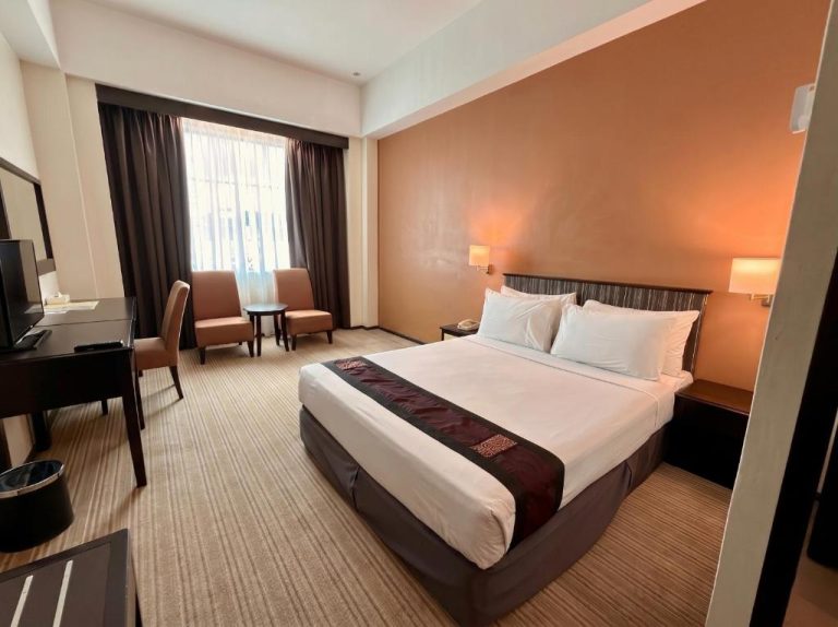 Habitación doble con cama king size y decoración en tonos cálidos en Hotel Seri Malaysia Lawas