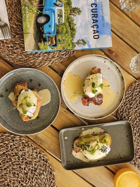Tres platos de eggs benedict con salmón, bacon y aguacate en el Yucca Mini Boutique Hotel Adults Only