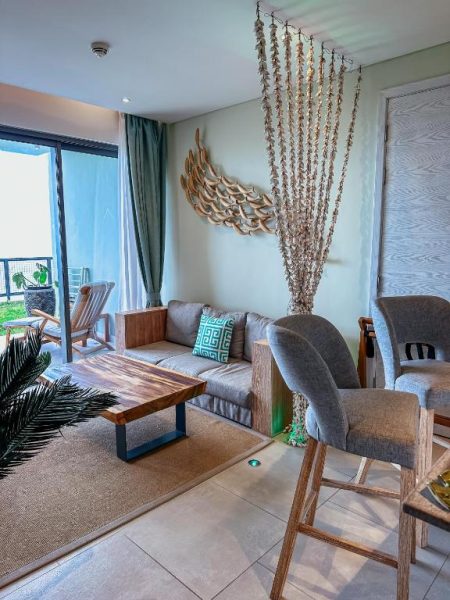 Sala de estar de suite con decoración tropical y alas decorativas en AQUA Boutique Hotel con vista al océano
